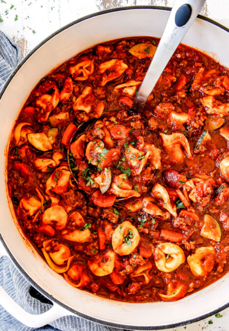top view of a white Dutch oven of sausage tortellini soup