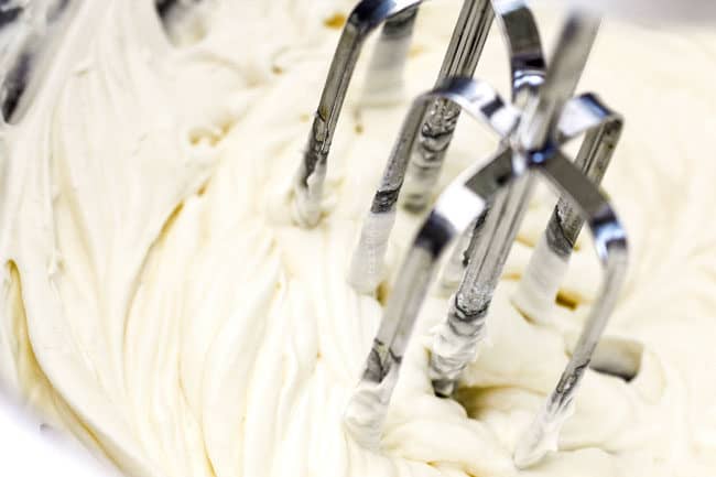 showing how to make ambrosia salad by beating heavy cream to make creamy dressing