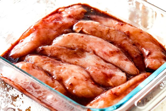 showing how to make hoisin chicken by marinating chicken in hoisin marinade in a glass dish