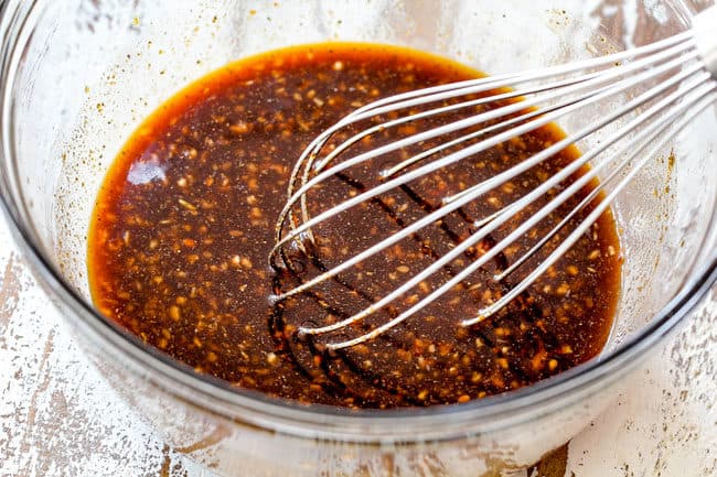showing how to make Korean Spicy Noodles by whisking together fire sauce of gochuchang, sesame oil, ginger, garlic and soy sauce