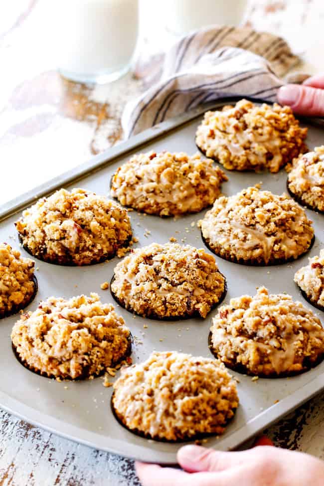 Showing how to make fresh pumpkin muffins from scratch by pulling the baked pumpkin muffins out of the oven