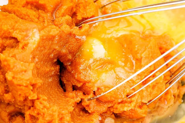 showing how to make pumpkin muffins from scratch by whisking pumpkin puree, eggs and sugar together in a mixing bowl.