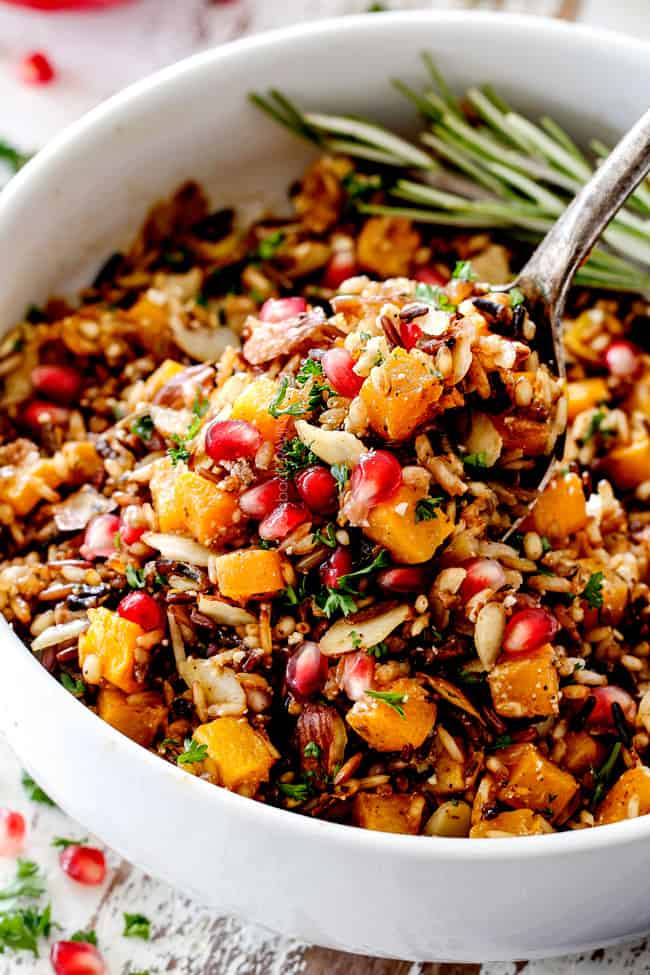 seasoned wild rice recipe with a spoon raising rice out of the bowl