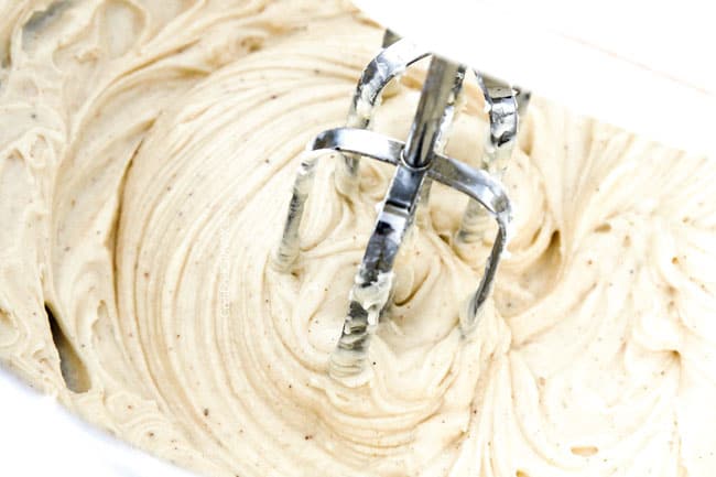 showing how to make poke cake beating frosting