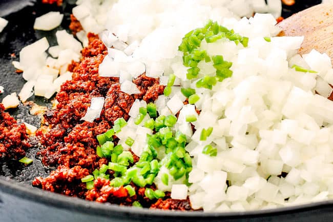 showing how to make queso fundido mexicano by adding onions and serrano pepper to chorizo in a skillet