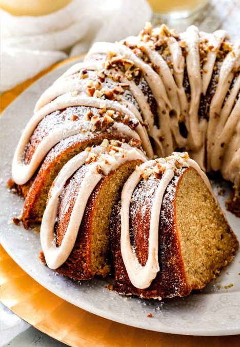 holiday eggnog cake on a white platter with three slices laying against the cake