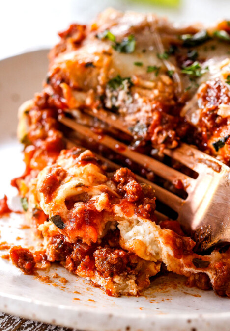 a fork cutting into a slice of classic lasagna