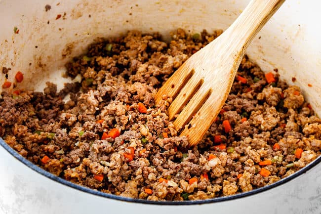 showing how to make classic lasagna by making homemade meat sauce with Italian sausage, lean ground beef, onions, garlic, carrots, and celery