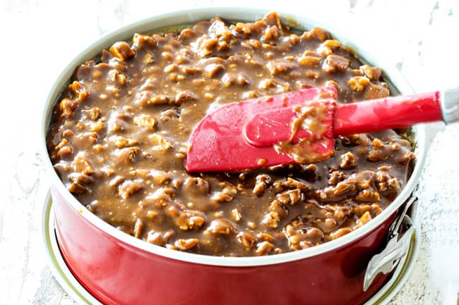 showing how to make pecan topping for Pecan Pie Cheesecake by spreading pecan topping over cheesecake