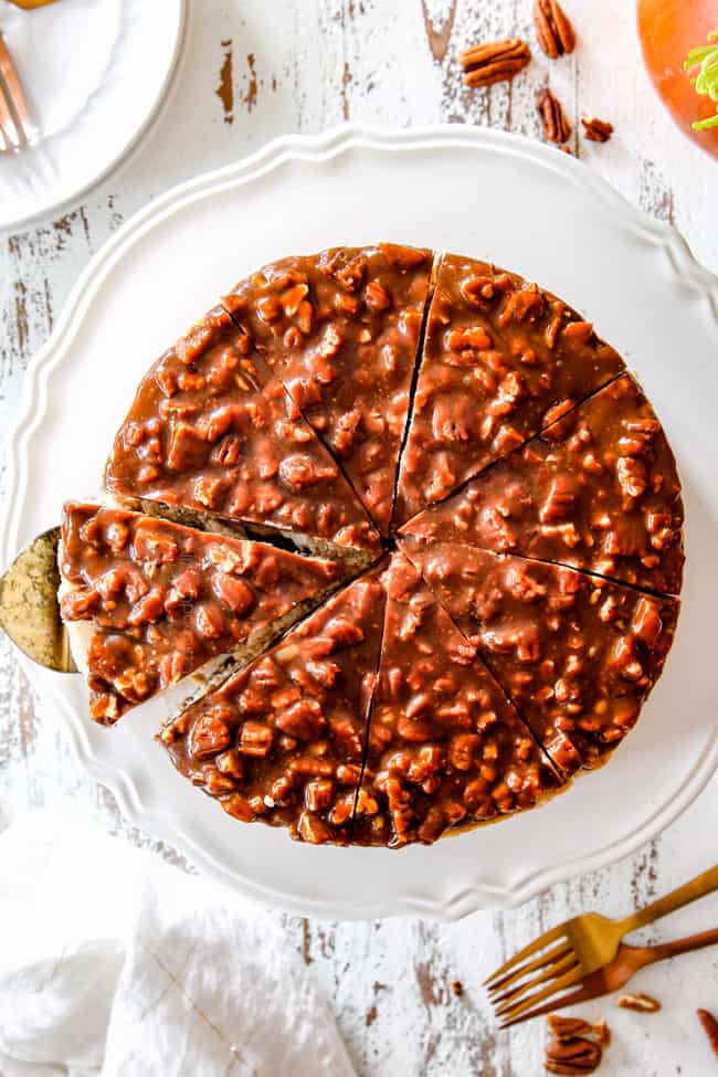 far away top view of taking a slice of pecan pie cheesecake on white pedestal