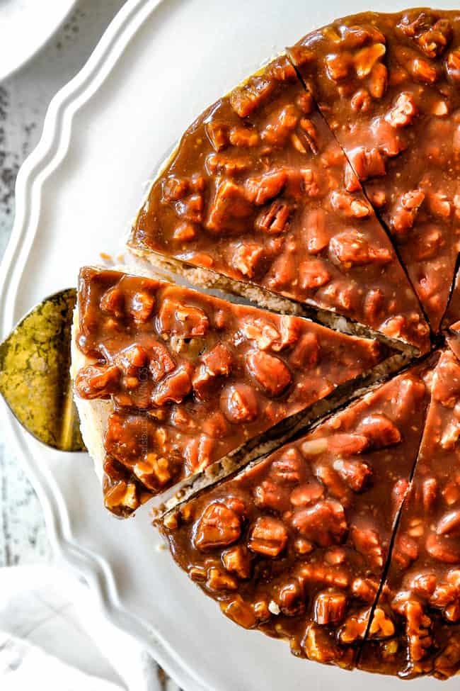 up close top view of taking a slice of pecan pie cheesecake on white pedestal