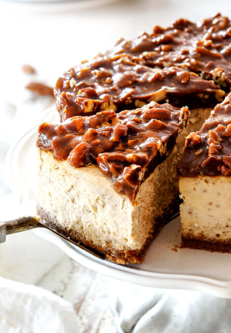 up close taking a slice of pecan pie cheesecake with graham cracker crust on a pedestal