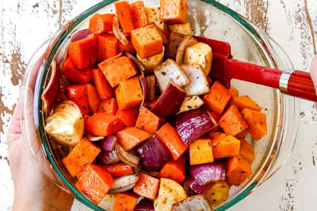showing how to make roasted root vegetables with balsamic by stirring the vegetables and balsamic together in a glass bowl