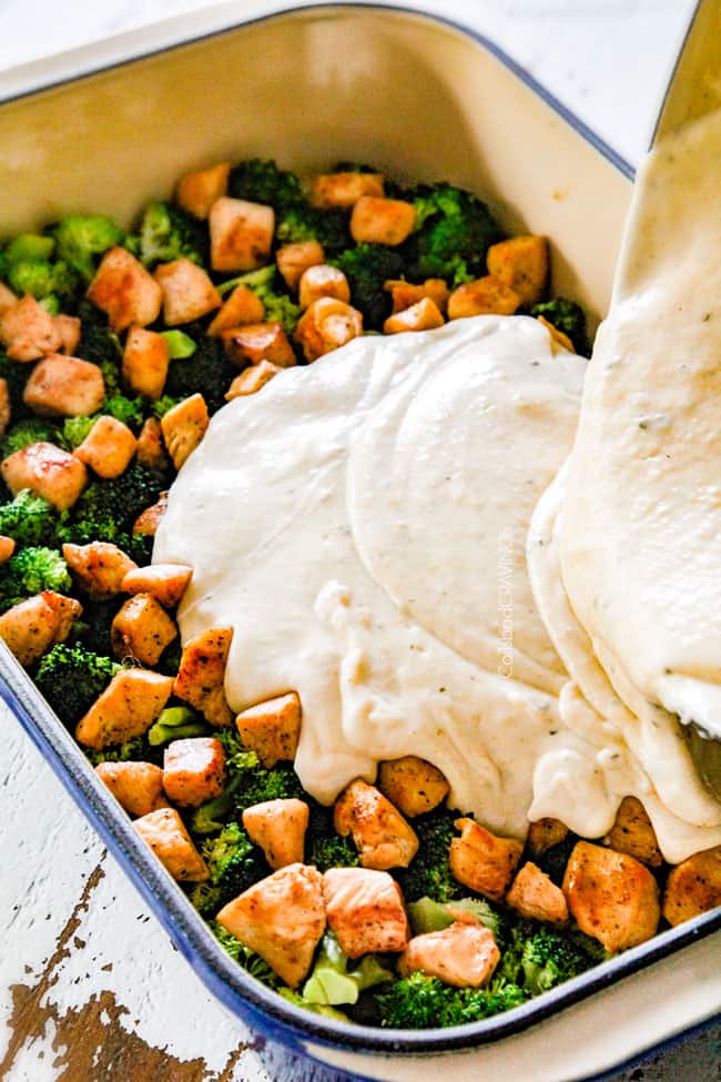 showing how to make chicken divan by pouring creamy sauce over chicken and broccoli