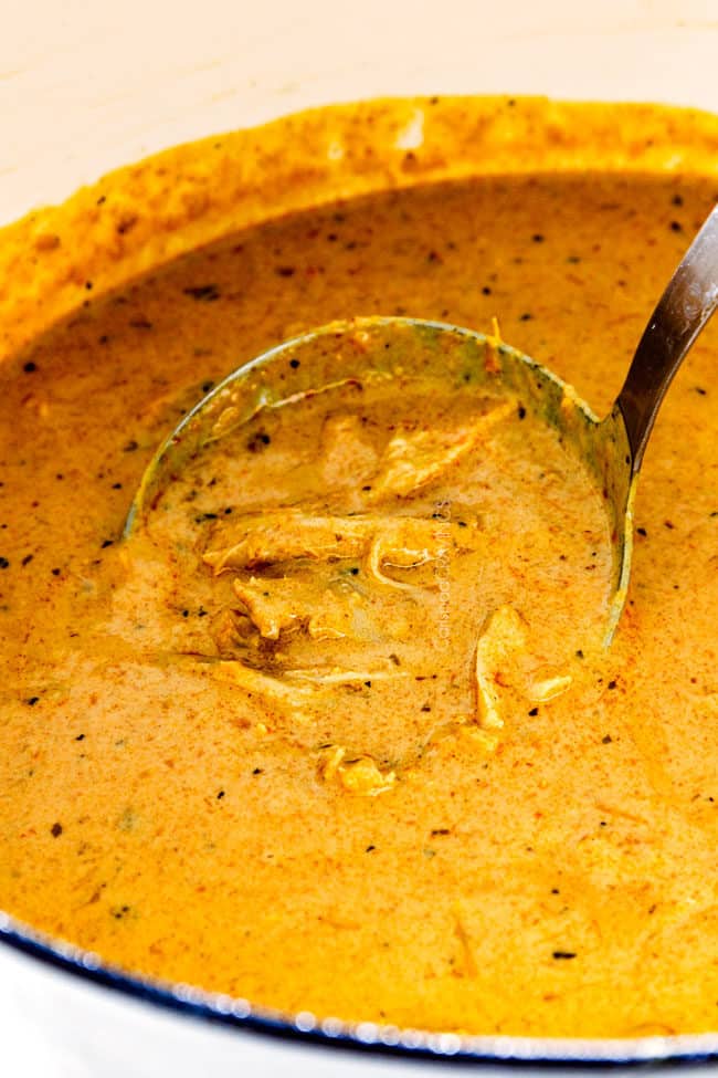 up close of creamy laksa with chicken in a white pot