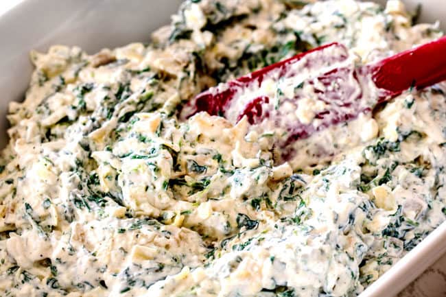 showing how to make easy spinach artichoke dip recipe by adding the mixed ingredients to a baking dish and spreading out