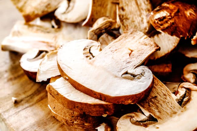 showing how to make Chicken Stroganoff by slicing mushorroms