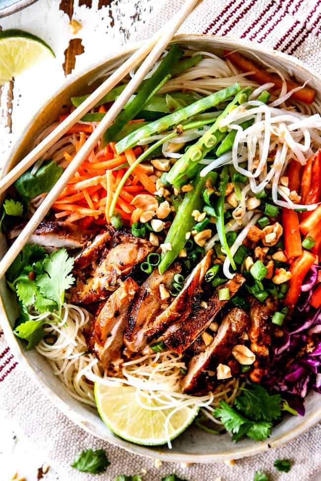 top up close view of Vietnamese noodle with rice noodles, lemongrass chicken, shredded carrots, julienned carrots, bean sprouts and snow peas