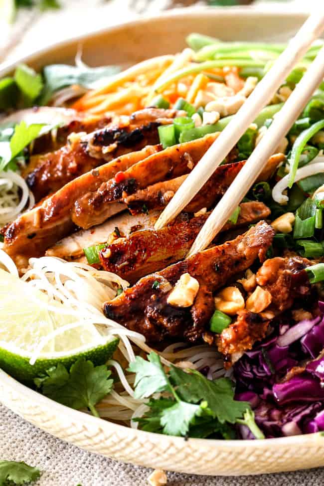 Vietnamese noodles with chopsticks picking up sliced lemongrass chicken