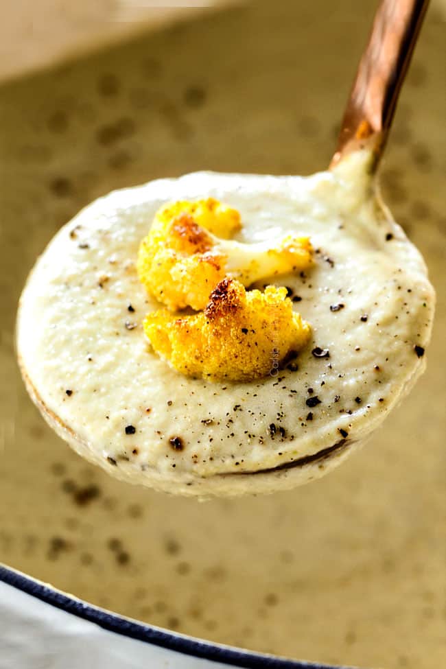 up close of a ladle of the best Cauliflower Soup with roasted cauliflower