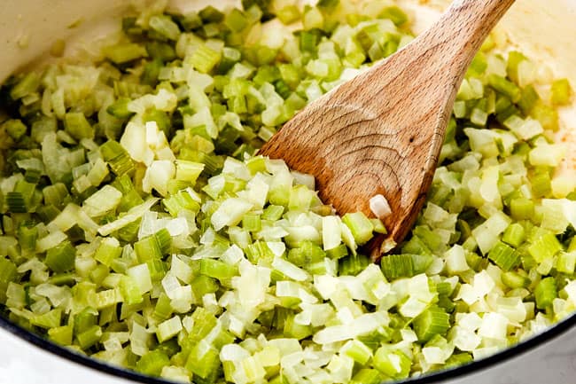 showing how to make cauliflower soup by cooking onions, celery, garlic and fennel in a white pot