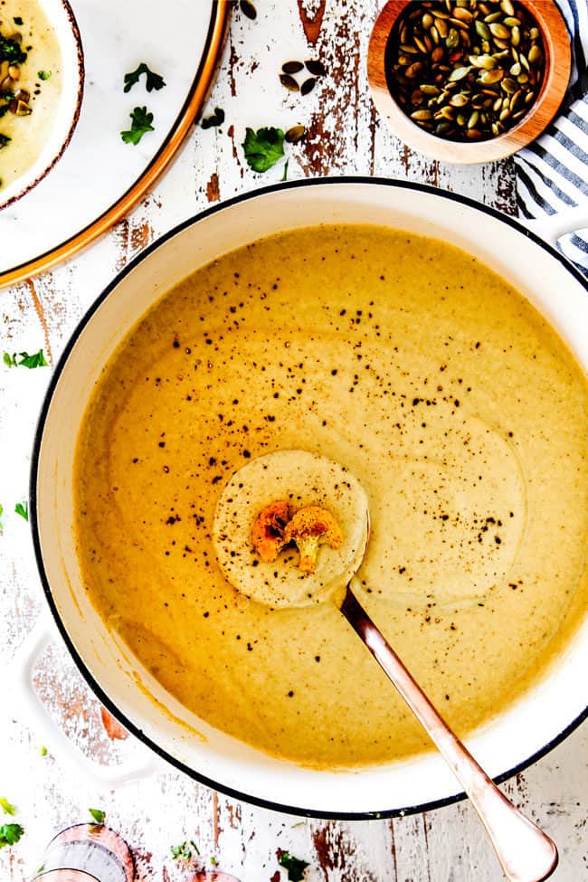 top view of easy cauliflower soup in a white soup pot with a ladle.
