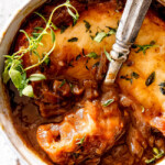 up close of top view of Best French Onion Soup with a spoonful of cheesy bread