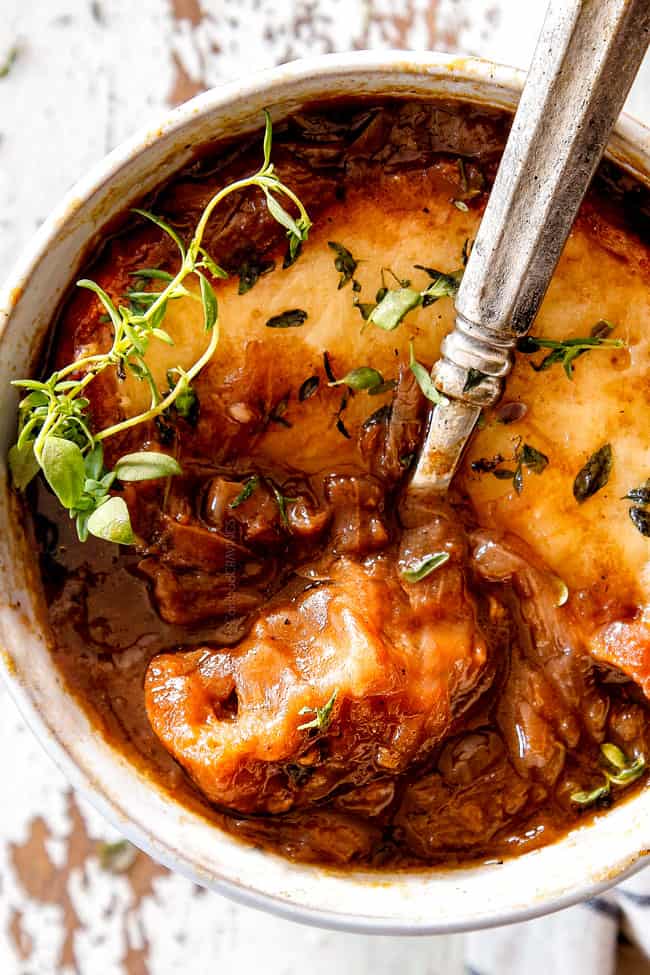 up close of top view of Best French Onion Soup with a spoonful of cheesy bread
