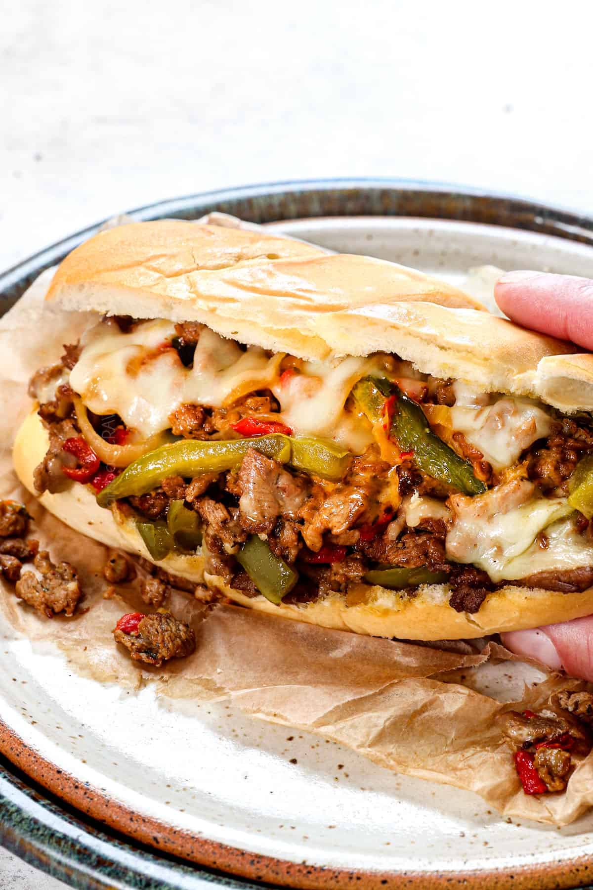 side view of easy Philly Cheesesteak recipe with the buns bursting with cheesy filling