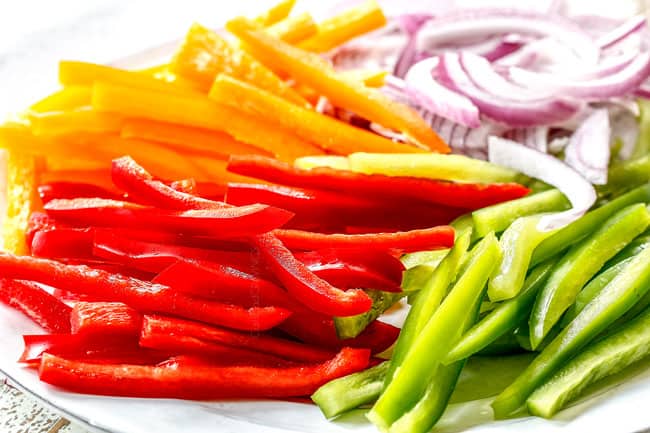 showing how to make pork fajitas by chopping bell peppers and red onion