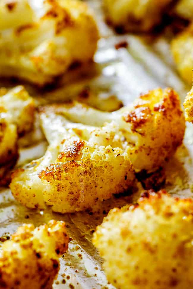 up close of a curry roasted cauliflower floret laying on a baking sheet