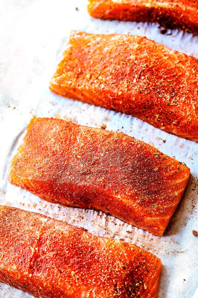 showing how to make Blackened Salmon by seasoning with blackened seasoning