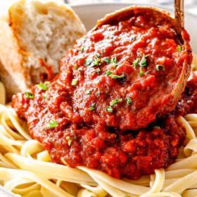 spooning marinara from scratch over noodles