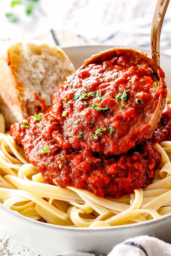 spooning marinara from scratch over noodles