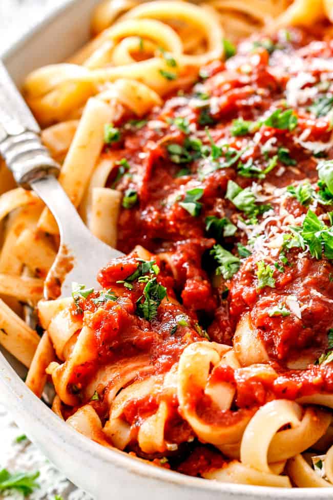 a fork in a bowls of pasta with homemade marinara sauce