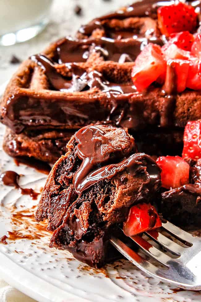up close of double chocolate waffles on a fork with strawberries