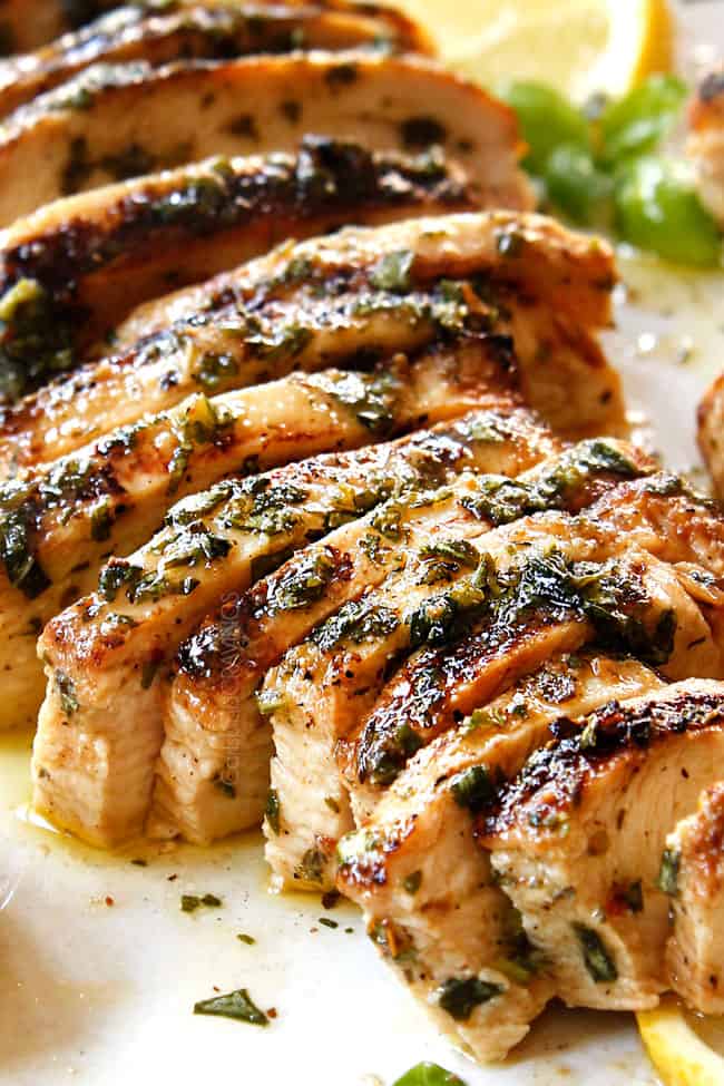 showing how to make grilled chicken salad recipe by thinly slicing grilled chicken breasts.