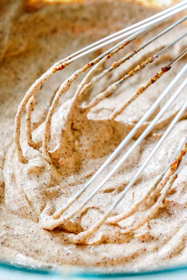 showing how to make chicken enchiladas by whisking together spices, sour cream and enchilada sauce