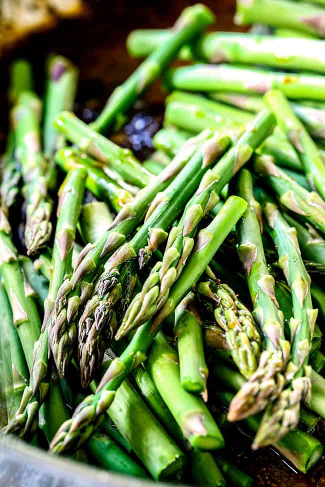showing how to make lemon pepper chicken and asparagus by cooking asparagus in a skillet