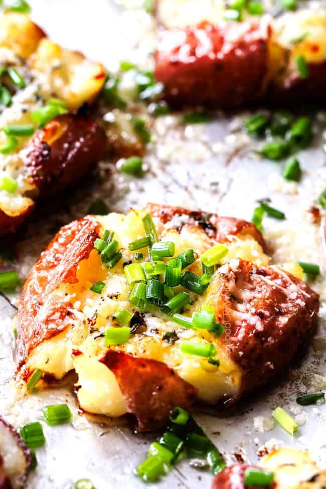 side view of smashed red potatoes with butter, garlic and chives