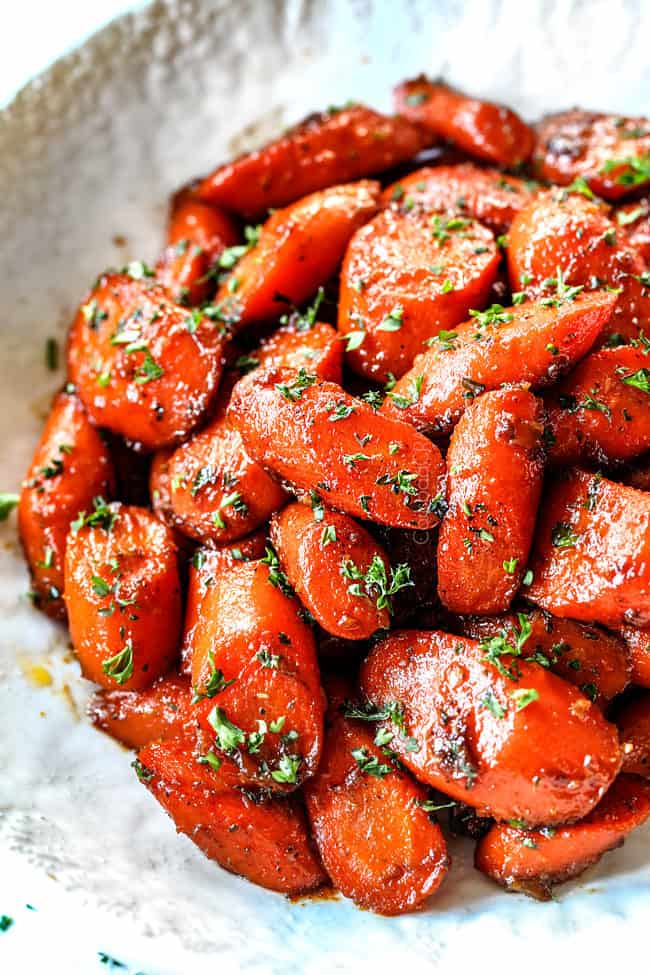 up close of brown sugar glazed carrots in a white bowl