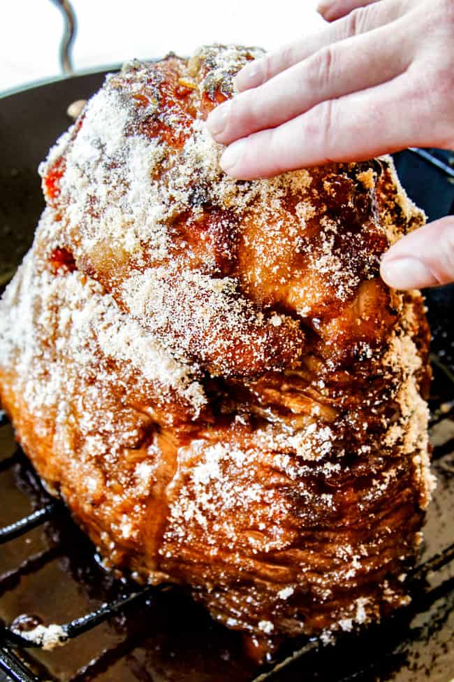 showing how to make honey baked ham by rubbing with sugar on the outside