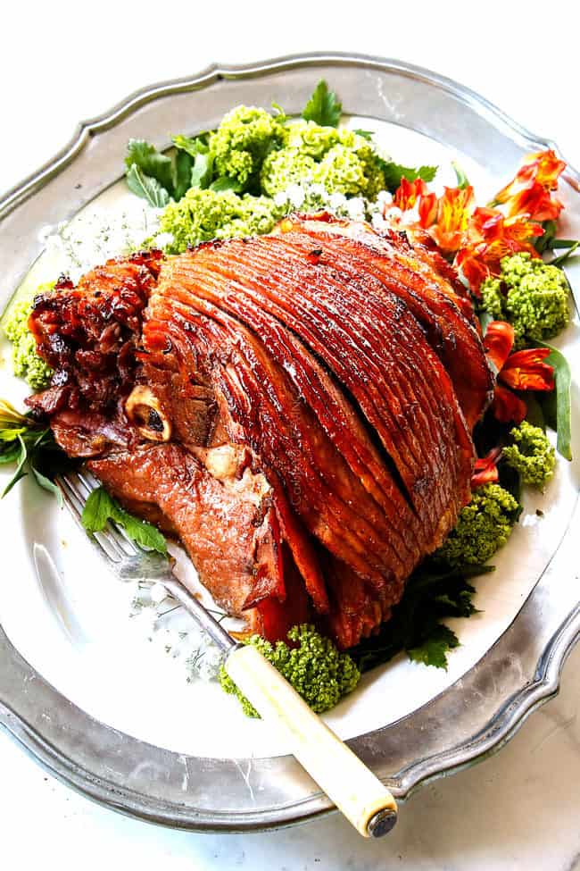 side view of honey glazed ham on a white platter