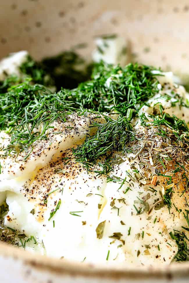showing how to make healthy dill sauce for salmon by adding Greek yogurt, dill, lemon juice, vinegar, oregano, salt and pepper to a bowl