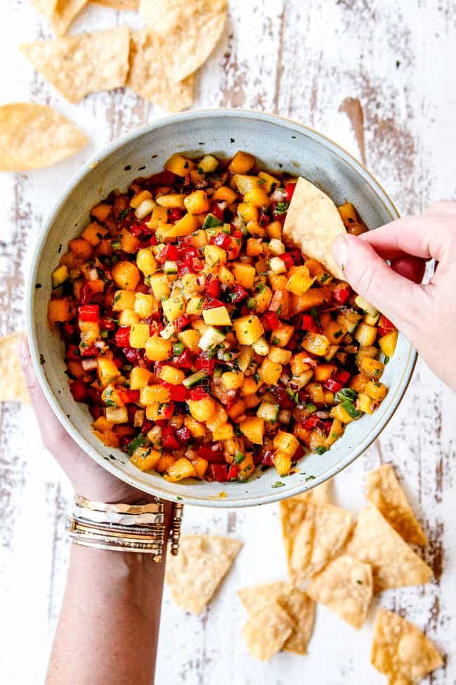 holding a bowl of mango black bean salsa
