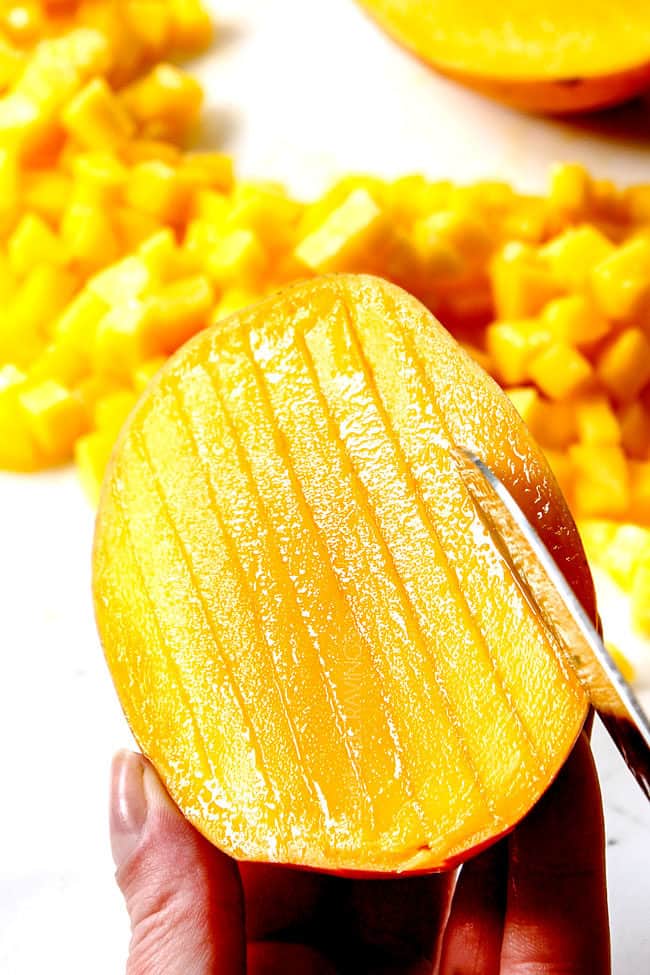 holding a mango showing how to chop for easy mango salsa recipe