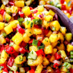 up close of two servings spoons scooping up mango salsa recipe