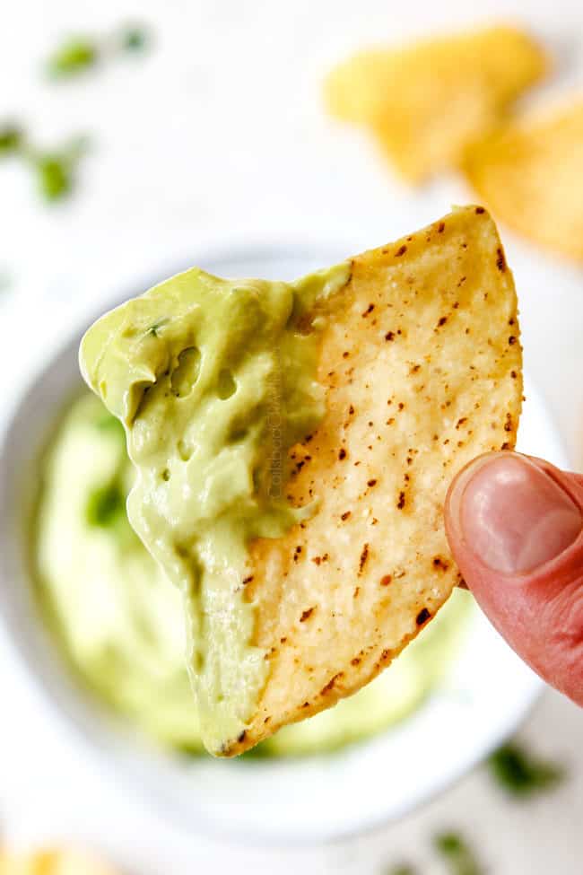 up close of a chip dipped in easy avocado crema