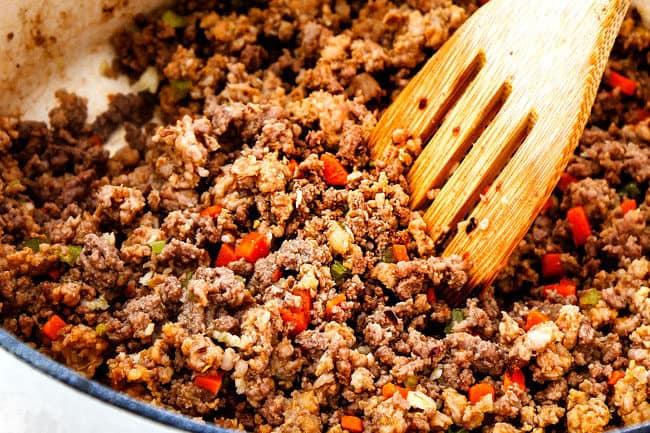 showing how to make the best bolognese sauce by cooking beef, Italian sausage, carrots, onions and celery in a large pot