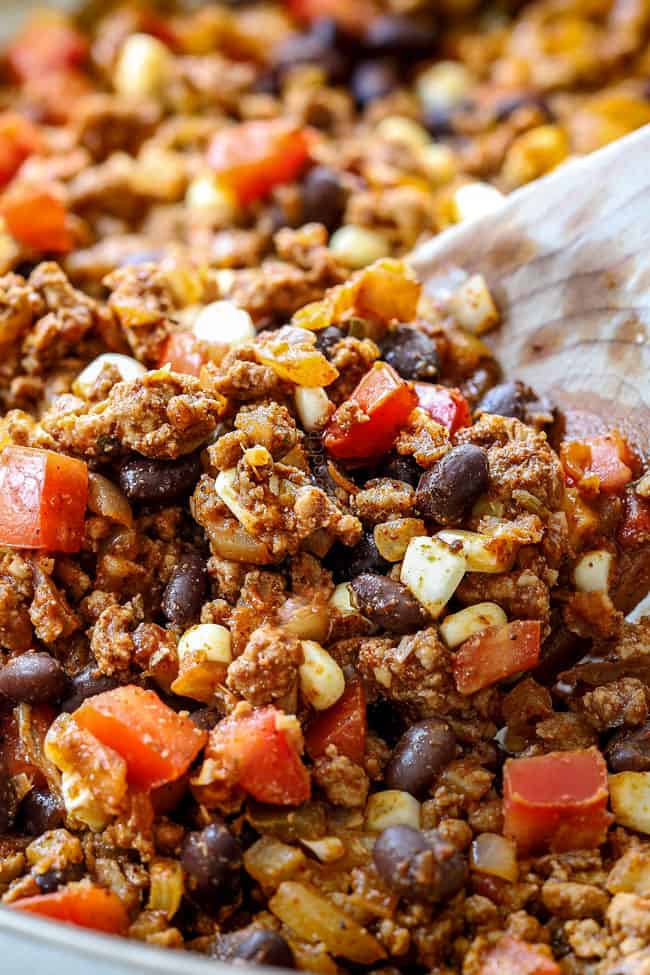 showing how to make stuffed avocados by cooking corn, black beans and tomatoes
